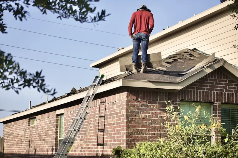 Professional roofer working on a residential roof in Linton Hall